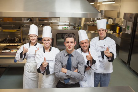 Restaurant Staff in front of large overhead commercial exhaust